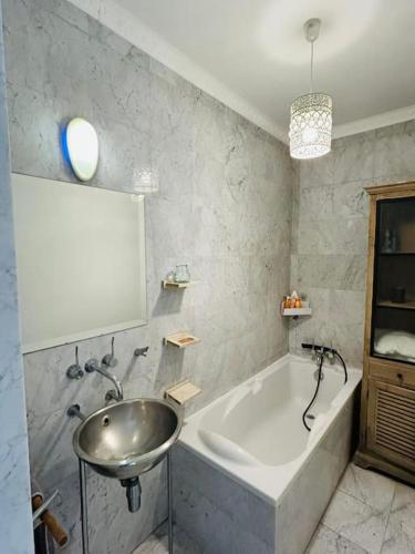 une salle de bain avec un lavabo et une baignoire dans l'établissement Appartement charmant parisien, à Paris