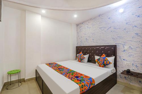 um quarto com uma cama com um cobertor colorido em FabExpress Victory em Lucknow