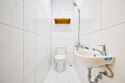 biała łazienka z umywalką i toaletą w obiekcie Bangreng Inn Hotel w mieście Bandung