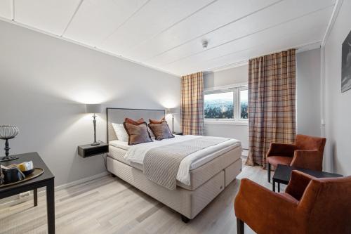 a bedroom with a bed and a desk and a chair at Spåtind Fjellhotell in Nord Torpa