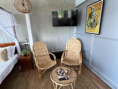 uma sala de estar com duas cadeiras e uma mesa em Kenno's Korner em Weligama