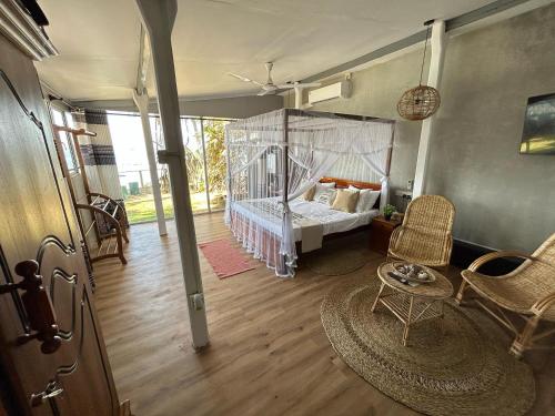 a bedroom with a bed with a canopy at Kenno's Korner in Weligama