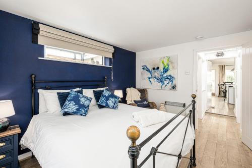 a bedroom with blue walls and a bed with blue pillows at Fisherman Cottage Llanfaes near Beaumaris in Llanfaes