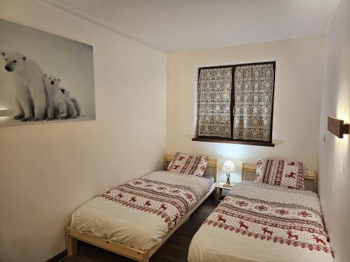 deux lits jumeaux dans une chambre avec fenêtre dans l'établissement Appartement Cosy, Vue Mont Blanc, Plein Centre, à Chamonix-Mont-Blanc