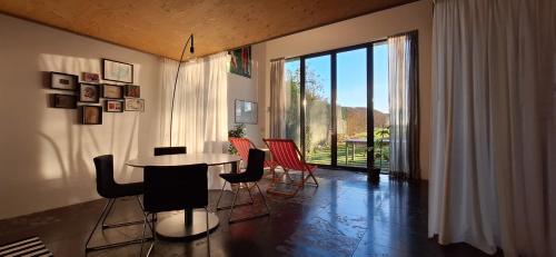 Cette chambre dispose d'une grande fenêtre et d'une table avec des chaises. dans l'établissement b&b Het Wolfshuis, à Bemelen