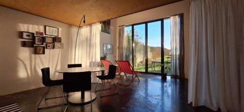 een kamer met een tafel en stoelen en een groot raam bij b&b Het Wolfshuis in Bemelen