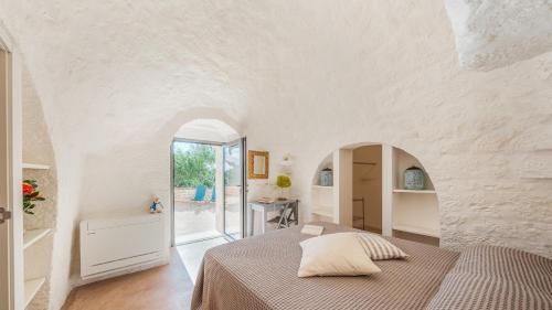 een slaapkamer met een bed in een witte kamer bij BORGO DELL'AGRUMETO 8, Emma Villas in Ostuni