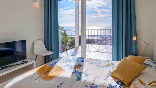 een slaapkamer met een bed en een groot raam bij VILLA GIOIA 8, Emma Villas in Sanremo