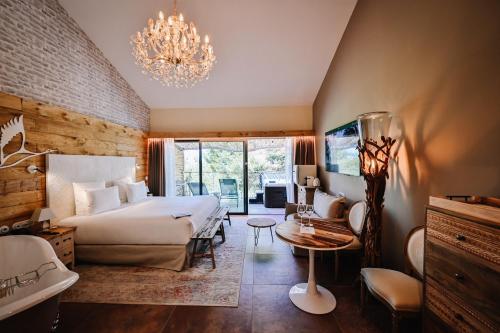 a bedroom with a large bed and a chandelier at Le Hameau Des Pesquiers Ecolodge & Spa, Curio Collection By Hilton in Hyères