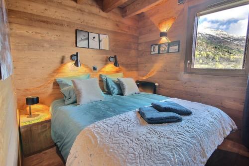 ル・モネティエ・レ・バンにあるChalet soleil terrasses vue serrechevalierholidaysの丸太小屋のベッドのある寝室