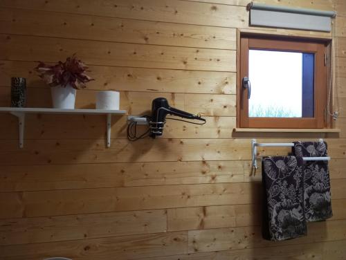 een badkamer met houten wanden en een raam bij Gîte du Chalet - Le studio en pleine nature 