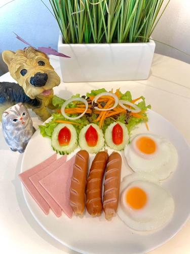 een bord voedsel met eieren en vlees op een tafel bij The Vet Boutique Hotel - SHA Extra Plus in San Kamphaeng