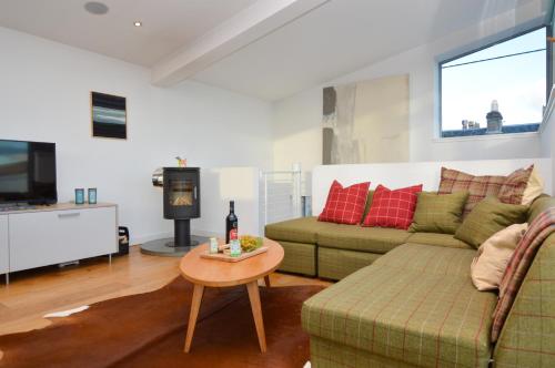 a living room with a couch and a table at Old Fire Station in Tighnabruaich