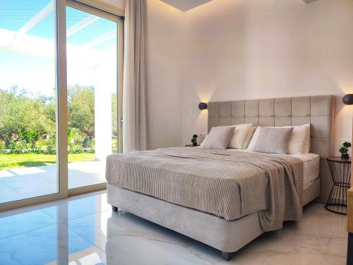 1 dormitorio con cama grande y ventana grande en Villa Mavra, en Plános