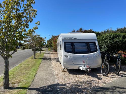 a white caravan parked on the side of a road at Cosy caravan fun in sunny Nelson with wifi! in Nelson