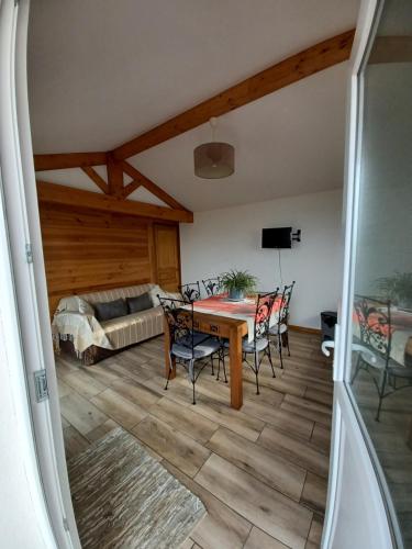 Zimmer mit einem Tisch, Stühlen und einem Bett in der Unterkunft Joli maisonnette in Bégaar
