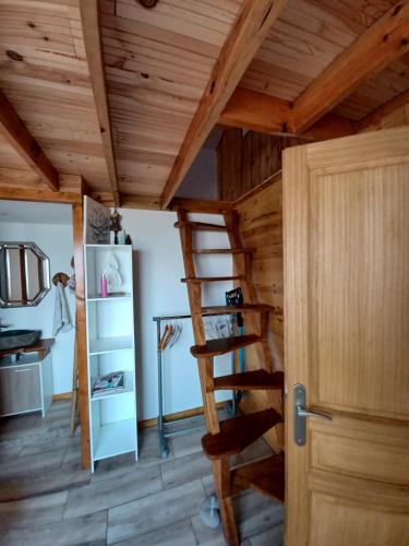 Zimmer mit Holzdecke und Holzleiter in der Unterkunft Joli maisonnette in Bégaar