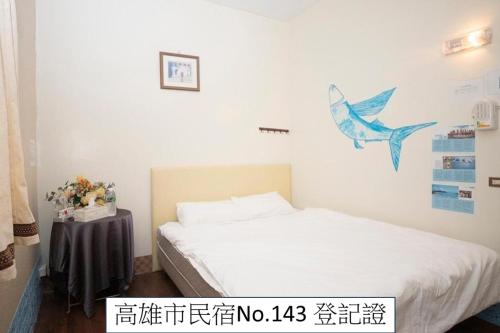a bedroom with a bed and a picture of a fish on the wall at 那瑪夏Lu-Mah民宿 in Namaxia