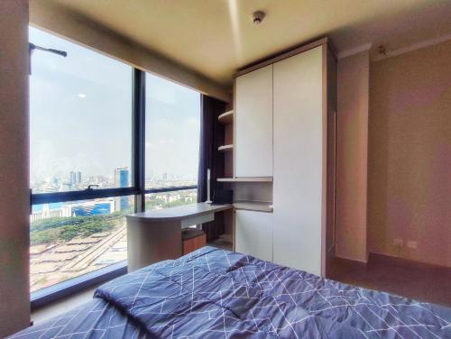 雅加達的住宿－BRAND NEW 2BR Apt Menara Jakarta, Jkt Inter Expo，一间卧室配有一张床、一张书桌和一个窗户。