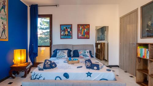 1 dormitorio con 1 cama grande y paredes azules en Ben House, en Santa Giusta