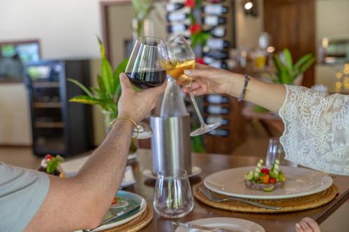 two people holding glasses of wine on a table at Alma Boutique Hotel in Jambiani