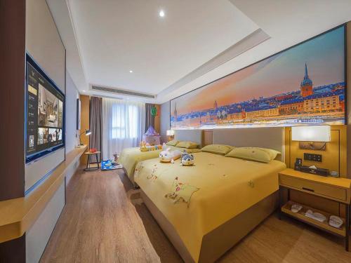 a bedroom with a large yellow bed with a painting on the wall at Vienna International Hotel Kunming longquan road Finance University in Kunming