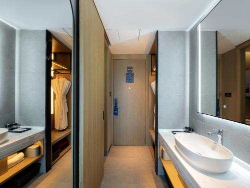 y baño con lavabo y espejo. en Park Inn by Radisson Shaoxing China Keqiao en Shaoxing