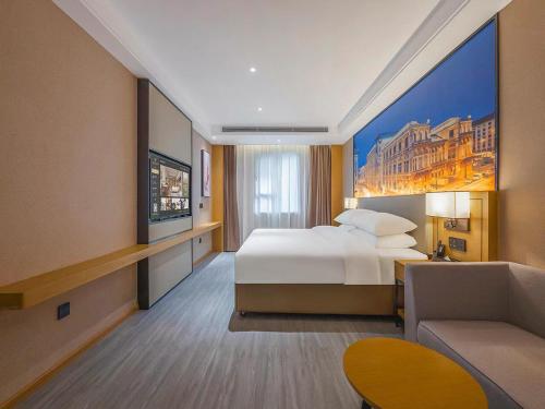 a large hotel room with a bed and a couch at Vienna International Hotel Kunming longquan road Finance University in Kunming