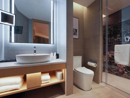 a bathroom with a sink and a toilet at Park Inn by Radission Tianjin Binhai International Airport in Tianjin