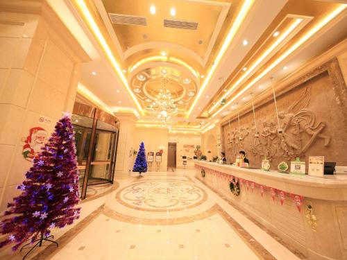 a large lobby with a christmas tree in the middle at Vienna International Hotel Shanghai Hongqiao Airport Convention and Exhibition Center Huaxu Highway in Qingpu