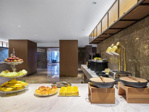 蘭州市にあるVienna International Hotel Lanzhou SASSEUR Outlets & Yellow Riversideのテーブルの上にたくさんの食べ物を並べたキッチン