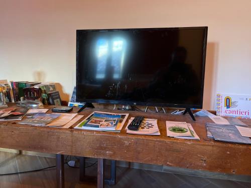 einen TV auf einem Holztisch mit Büchern in der Unterkunft Civico16 Appartamento in LʼAquila
