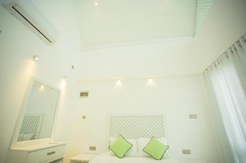 um quarto com um espelho e uma cama com almofadas verdes em Greencliff Mirissa em Mirissa