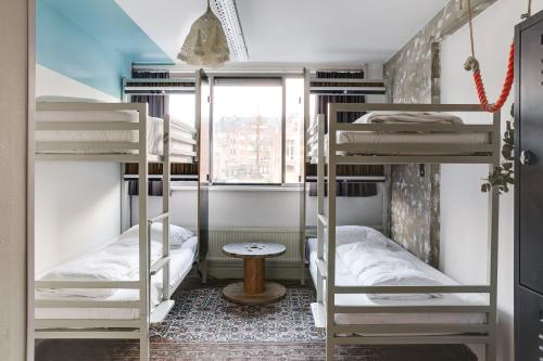 two bunk beds in a room with a window at ClinkMama in Amsterdam