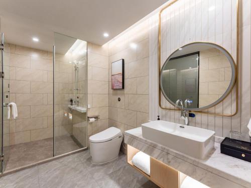 a bathroom with a toilet and a sink and a shower at Vienna International Hotel Xiamen Tong'an Industrial Concentration Area in Tong'an