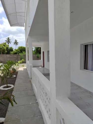 a white house with white walls and a courtyard at Butah Gardens Watamu in Gede