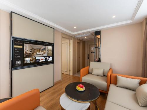 a living room with a couch and a table at Vienna International Hotel Xiamen Tong'an Industrial Concentration Area in Tong'an
