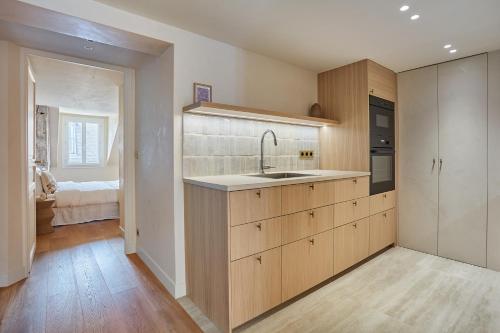 a kitchen with wooden cabinets and a sink at Apartment Place Vendome by Studio prestige in Paris