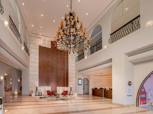 een grote lobby met een grote kroonluchter in een gebouw bij Park Inn by Radisson Beihai Silver Beach Wanda Plaza in Beihai