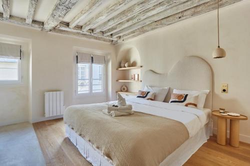 een witte slaapkamer met een groot bed in een kamer bij Apartment Place Vendome by Studio prestige in Parijs