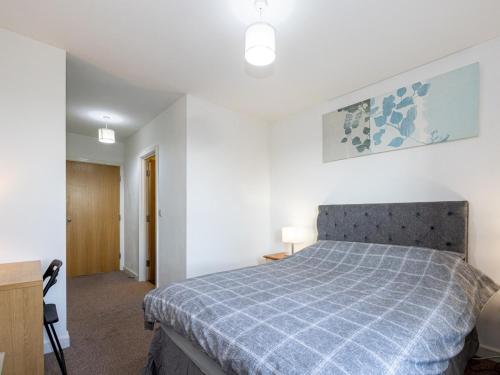 1 dormitorio con 1 cama con colcha azul a cuadros en Pass the Keys Free Parking and Walking Distance Etihad Coop Arena en Mánchester