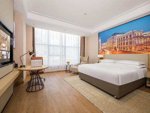 una camera d'albergo con un grande letto e una TV di Vienna International Hotel Wudu Gujinli Longnan a Longnan