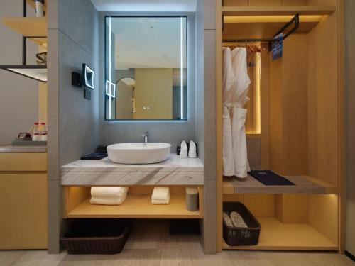 a bathroom with a sink and a mirror at Park Inn by Radisson Chengdu FengHuang Mountain Sports Park in Xindu