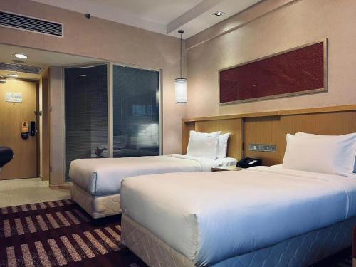 a hotel room with two beds and a tv at Park Inn by Radisson Shanghai Downtown in Shanghai