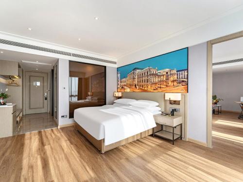 a bedroom with a large white bed and a bathroom at Vienna International Hotel Chongqing Jiangbeizui Financial Center in Chongqing