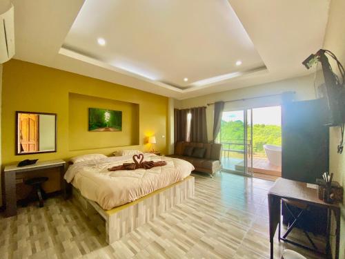 a bedroom with a bed and a desk and a window at Kwainoy Riverpark in Sai Yok