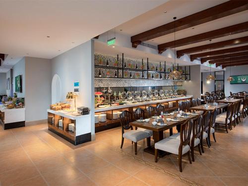 uma sala de jantar com uma mesa longa e cadeiras em Park Inn by Radisson Beihai Silver Beach Wanda Plaza em Beihai