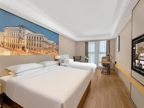 a hotel room with two beds and a flat screen tv at Vienna International Hotel Linqu Wanda Plaza in Weifang