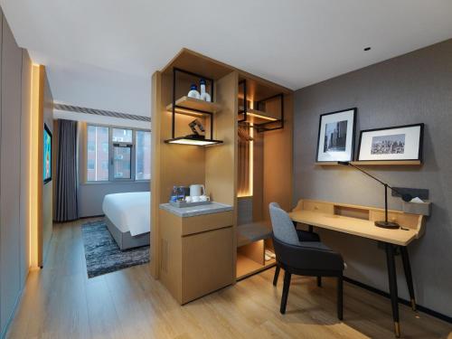 ein Hotelzimmer mit einem Bett, einem Schreibtisch und einem Schreibtisch in der Unterkunft Park Inn by Radisson Shandong Yucheng High-tech Zone Detpak Plaza in Yucheng