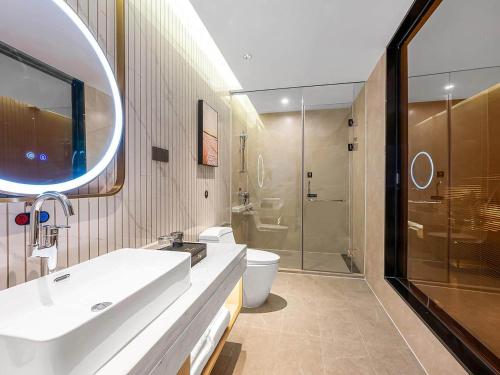 a bathroom with a sink and a toilet and a shower at Vienna International Hotel Xianyang International Airport Hotel in Xianyang